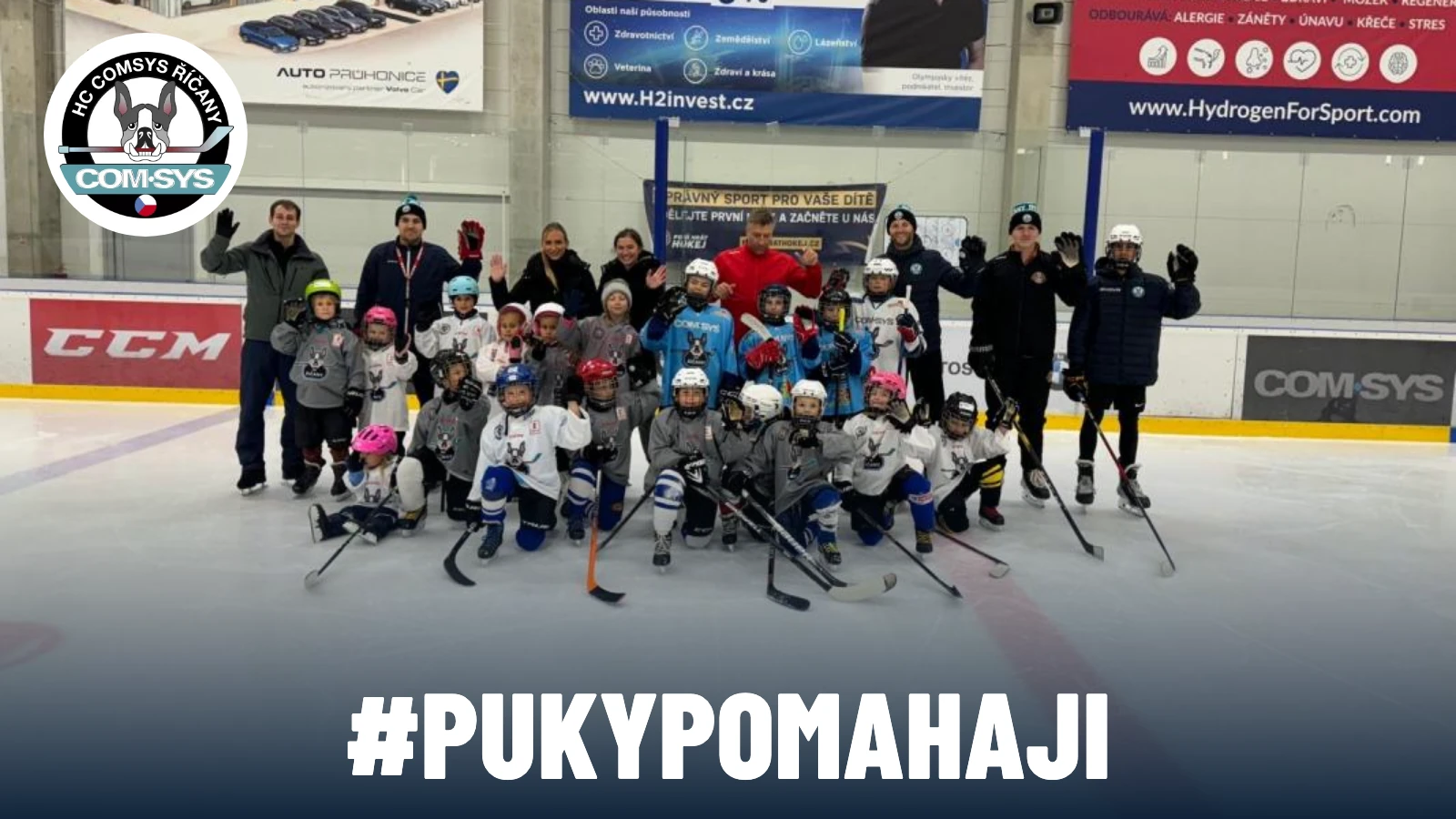Děti a trenéři HC COM-SYS Říčany na ledě, logo klubu a nápis #PUKYPOMAHAJI.